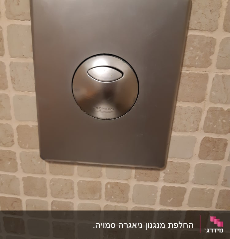 לחצן נירוסטה להדחת אסלה על קיר אריחים